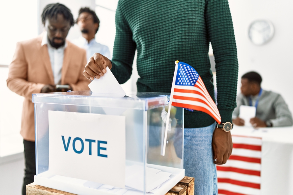 Young,American,Voter,Man,Smiling,Happy,Putting,Vote,In,Voting